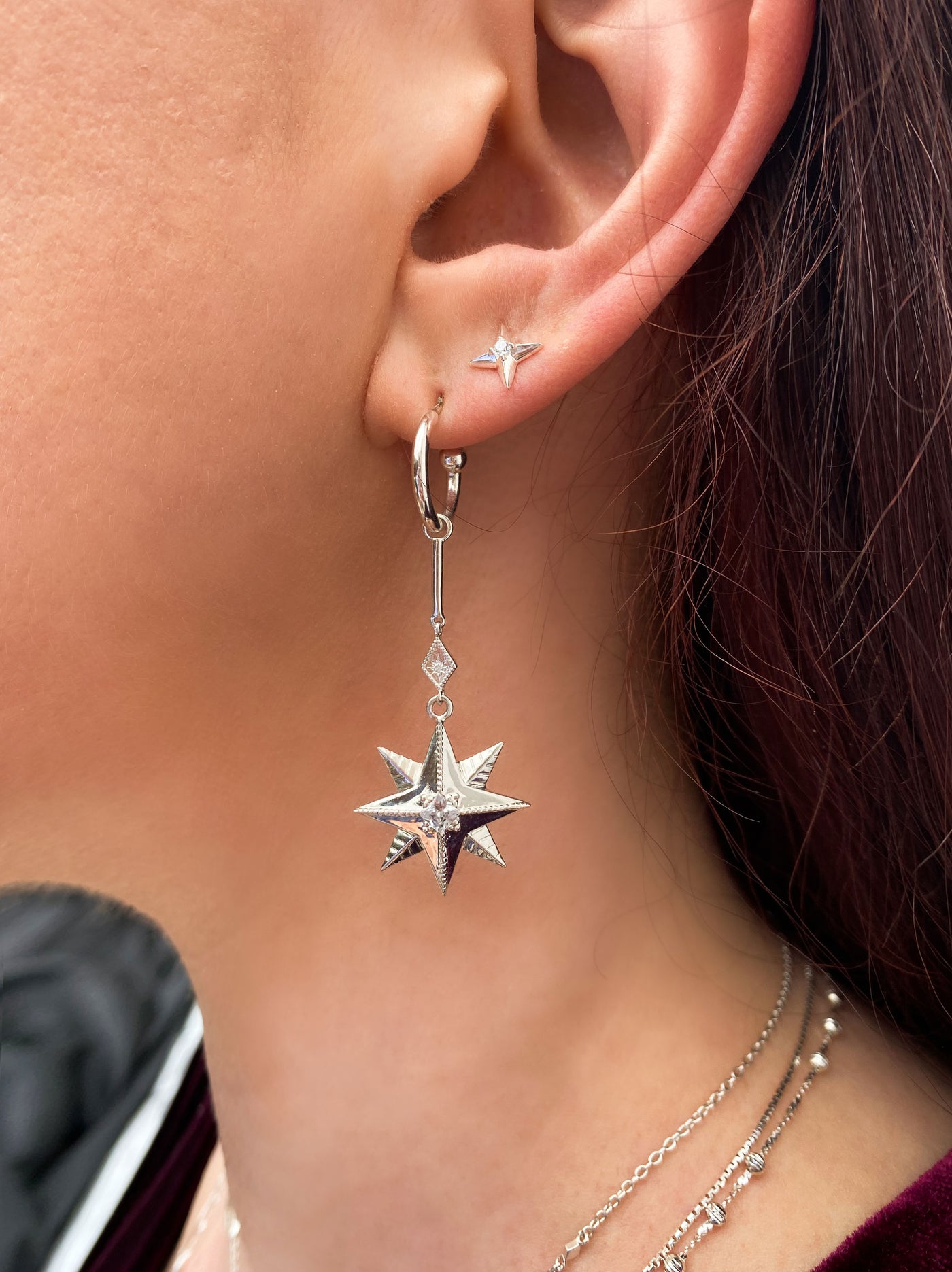 Model wearing statement sterling silver bar star drop hoop earrings with CZ crystals and dainty star stud