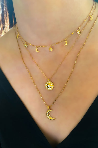 Model wearing gold plated sterling silver 3D engraved star coin necklace with CZ crystal, layered with moon necklace and dainty moon and star choker