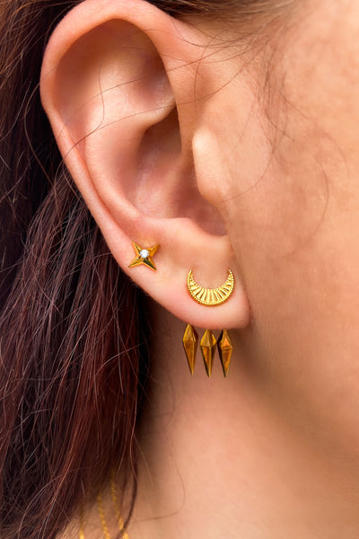 Model wearing gold plated sterling silver engraved moon front back ear jackets with hanging spikes and star stud with CZ crystal