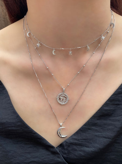 Model wearing sterling silver engraved tiger coin necklace on bobble chain with dainty star and moon choker and moon pendant