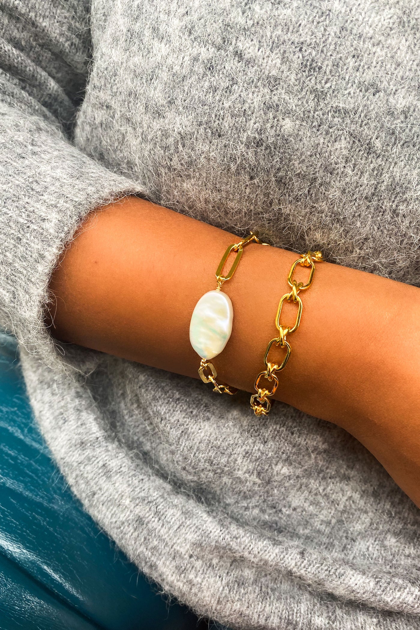 Model wearing gold plated sterling silver criss-cross link chunky chain bracelet with statement freshwater pearl bracelet 