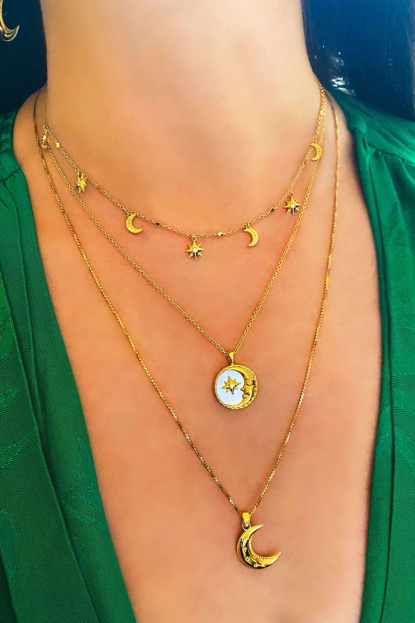 Model wearing gold moon and star choker with CZ crystals, layered with engraved mother of pearl moon, coin pendant and moon necklace 